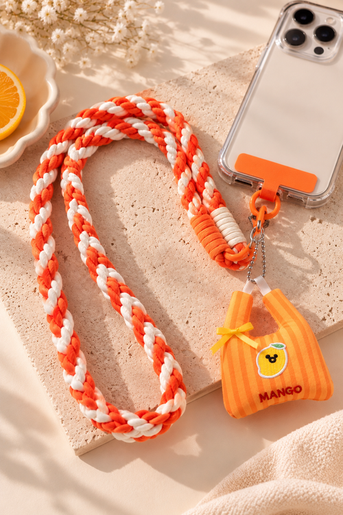 Bijou de téléphone Léonie tressé orange et blanc, avec attache sur une coque de téléphone