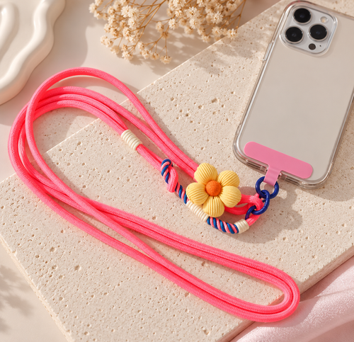 Bijou de téléphone Adèle à fleur jaune, fixé à une coque transparente par son attache rose