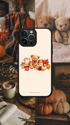 Coque de téléphone Miel à motif ourson sur fond crème, présentée dans un décor cosy avec des citrouilles et un plaid.