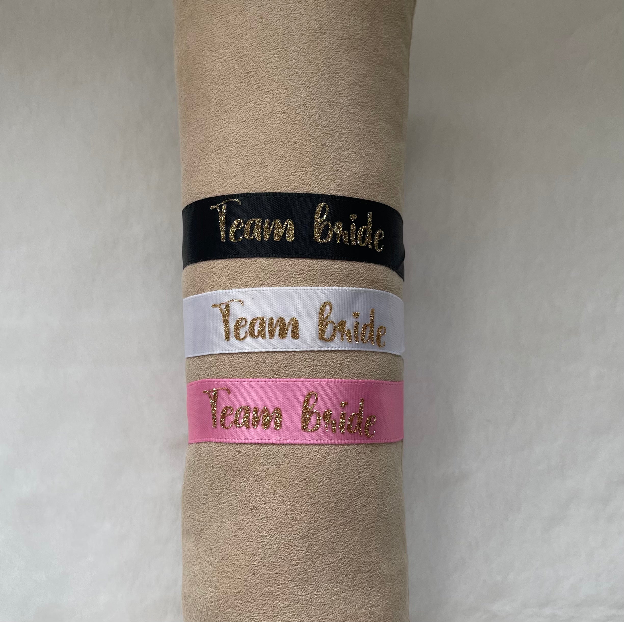 Présentation des 3 bracelets couleur noir, blanc et rose avec inscription "Team bride"